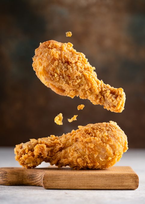 Delicious and crispy fried chicken legs on vintage  background